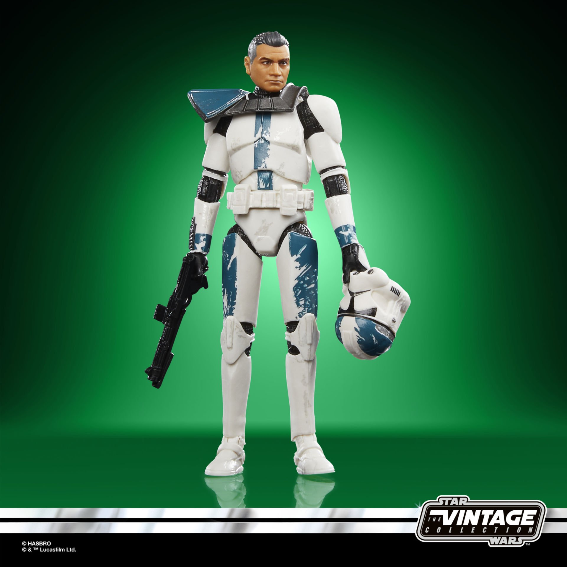 Beyaz ve mavi üniformalı bir Star Wars aksiyon figürü, yeşil bir arka plan üzerinde bir silah ve kask tutuyor.