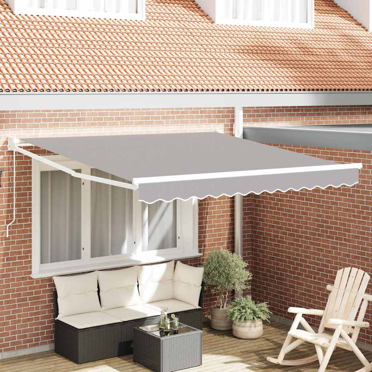 Tenda da sole grigia sopra la finestra. Sotto, un'area salotto con cuscini e un tavolo. Piante e sedia a dondolo sul patio.