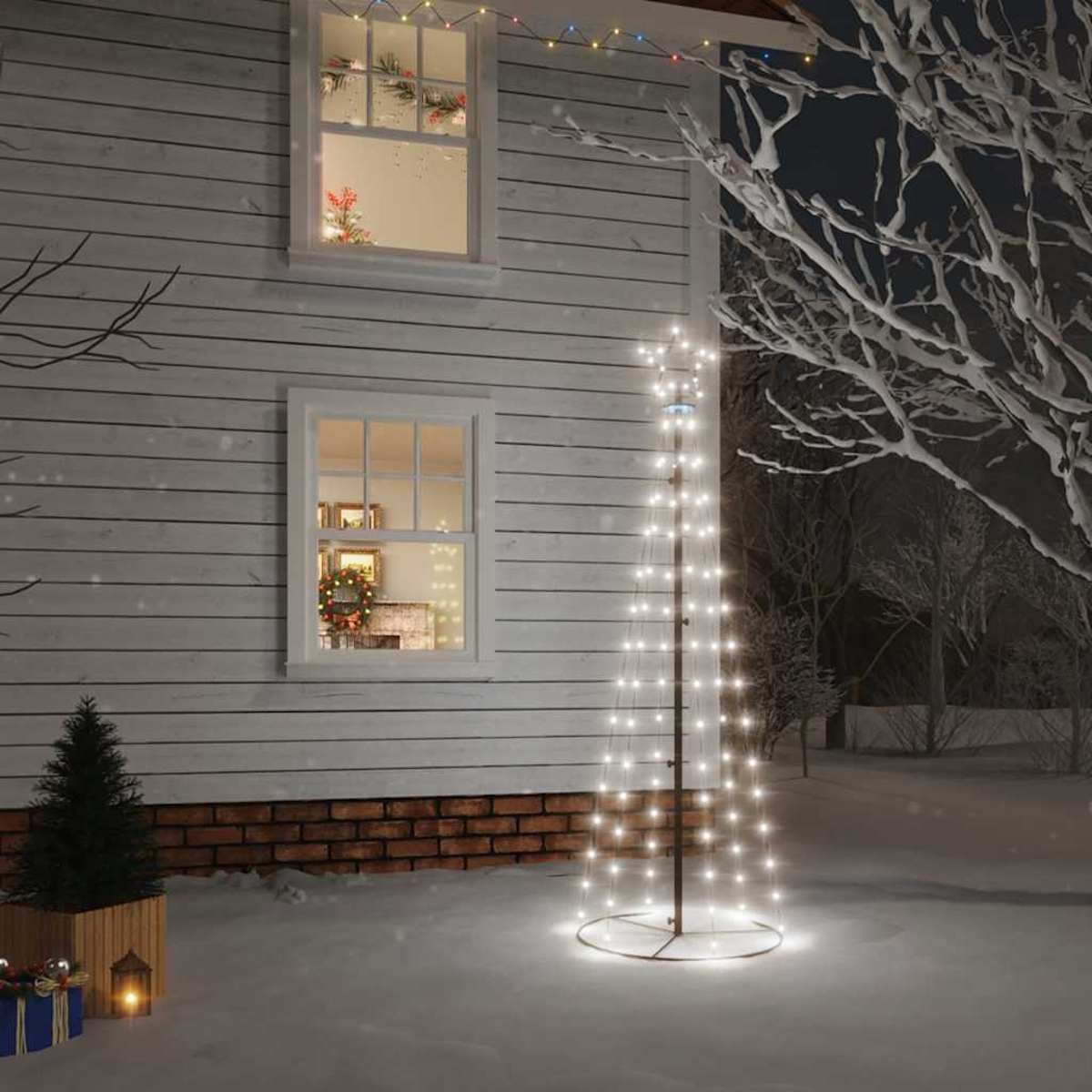 Eine verschneite Szene mit einem Haus und einem beleuchteten Weihnachtsbaum im Freien. Fenster zeigen Dekorationen. Andere Dekorationen sind vorhanden.