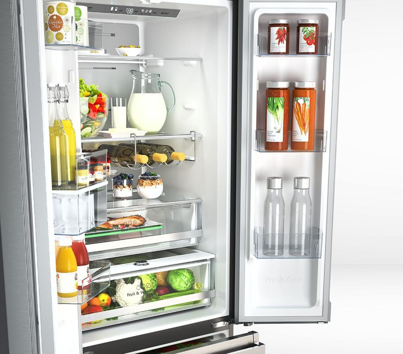 Ein geöffneter Kühlschrank voller Lebensmittel: Obst, Gemüse, Getränke und andere Lebensmittel. Gläser, Flaschen und Behälter sind sichtbar.