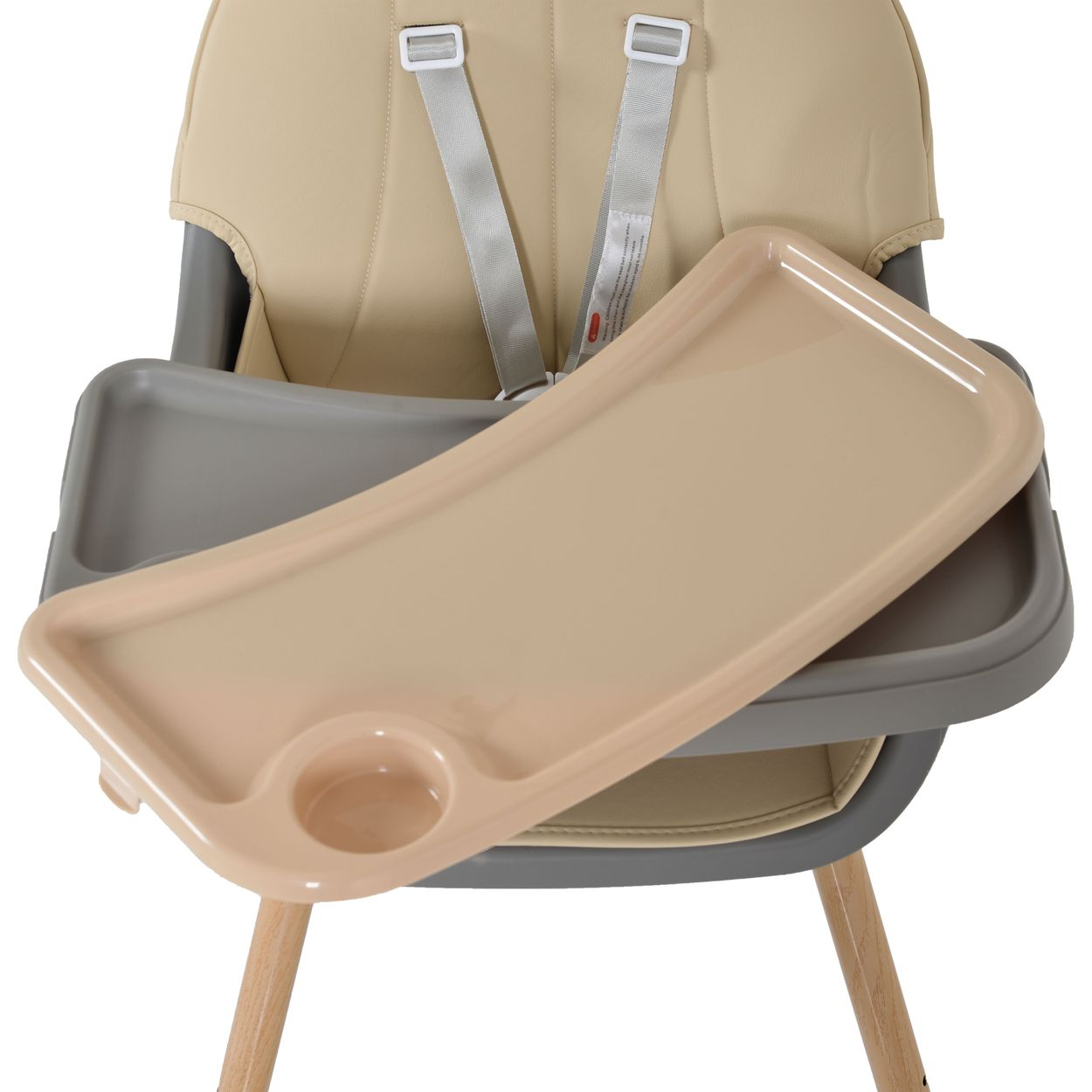Ein beigefarbener und grauer Babyhochstuhl mit Tablett. Das Tablett ist geöffnet. Der Stuhl hat Sicherheitsgurte und Holzbeine.
