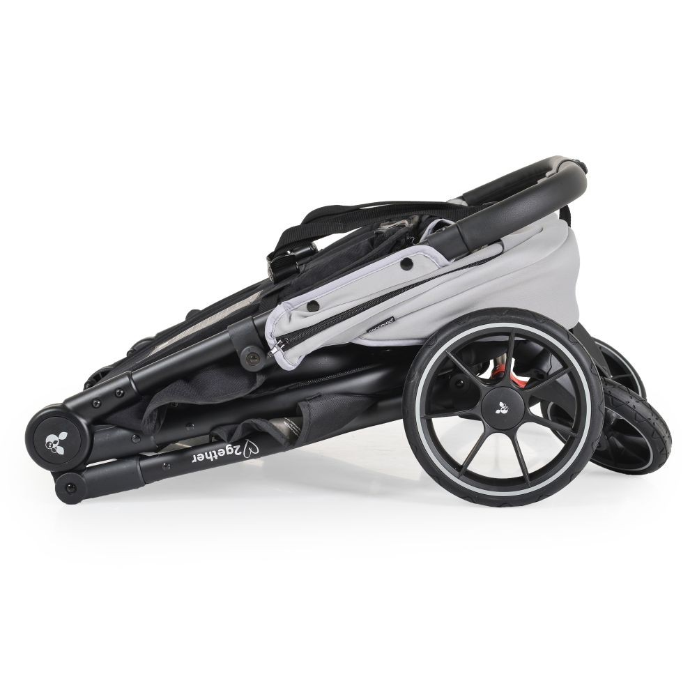 Ein zusammengeklappter grauer und schwarzer Kinderwagen mit schwarzen Rädern und einem Griff. Der Kinderwagen steht auf weißem Hintergrund.