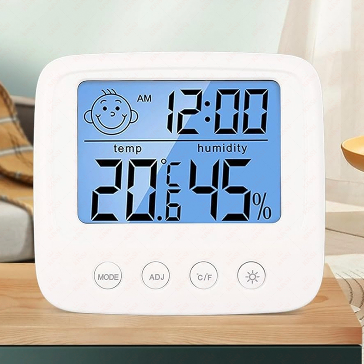 Weiße Digitaluhr, die Zeit, Temperatur und Luftfeuchtigkeit anzeigt. Merkmale sind ein lächelndes Gesicht, Knöpfe und ein blauer Bildschirm.