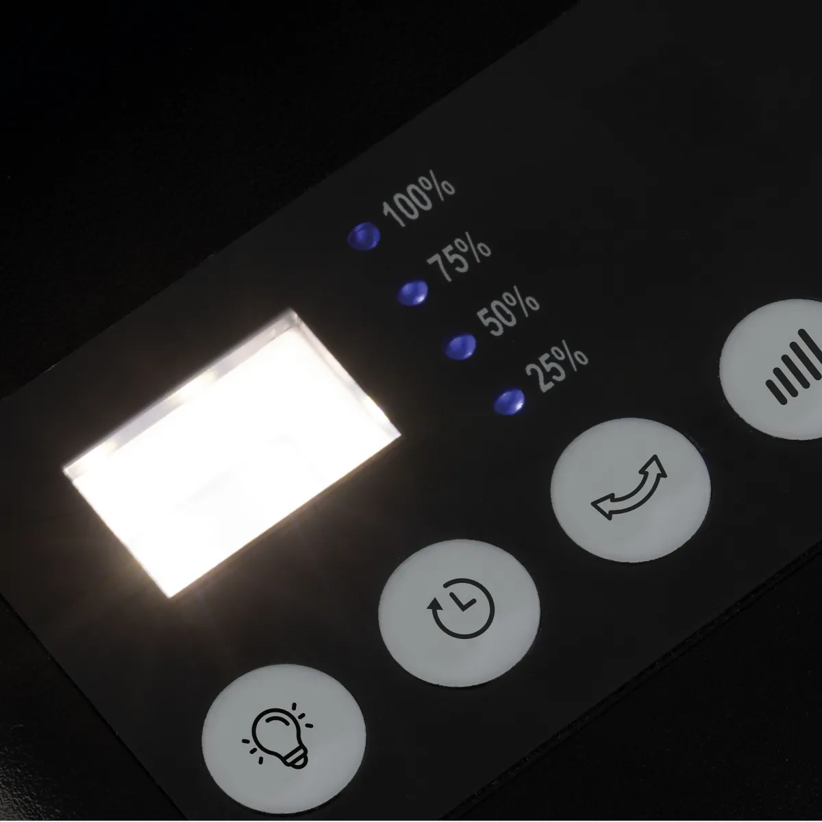 Panel de control negro con pantalla iluminada, indicadores de porcentaje y botones de función. Los botones incluyen configuraciones de luz, tiempo y otras opciones.