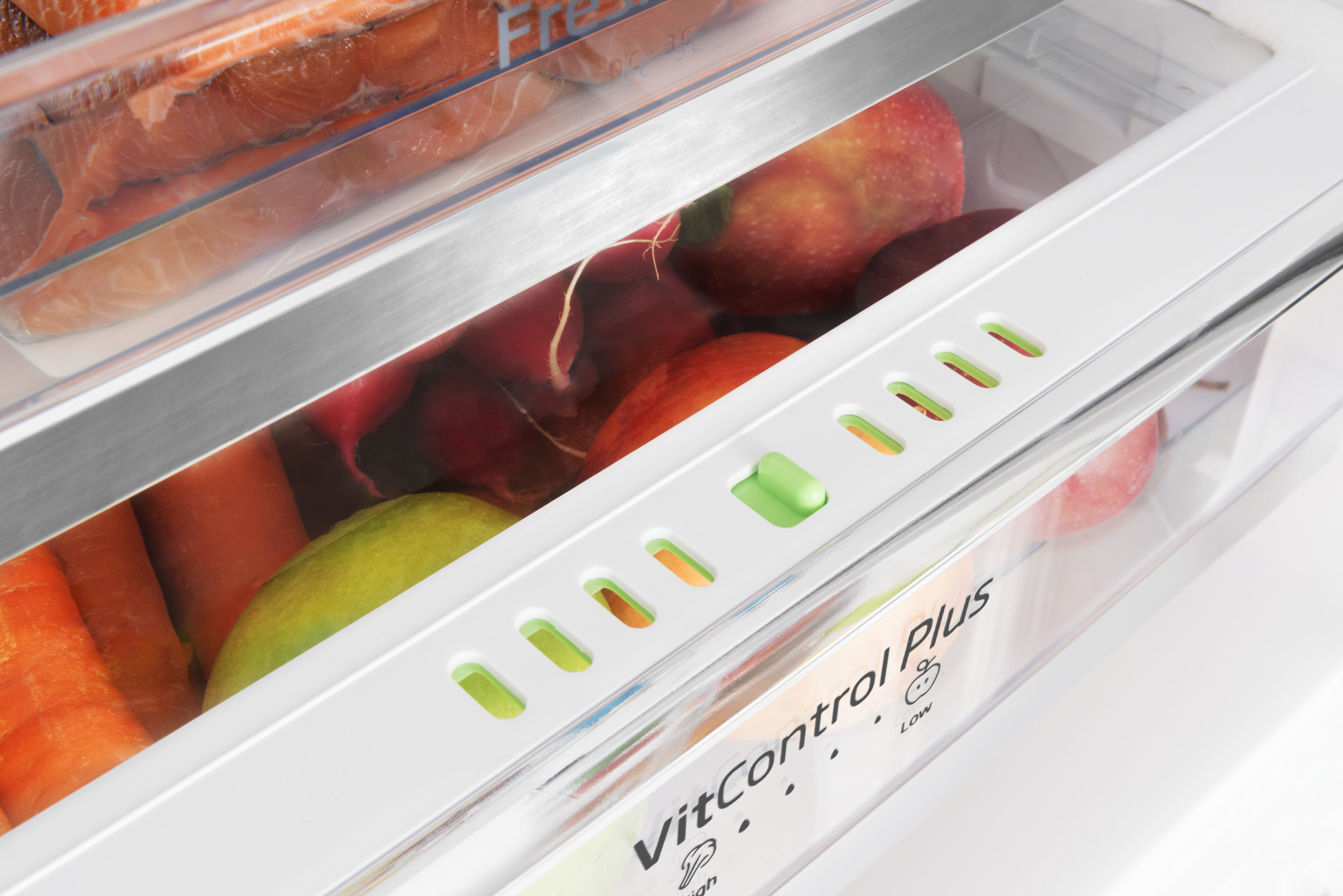 In einem Kühlschrank: Lachs, Äpfel, Radieschen, Karotten und eine grüne Gurke sind sichtbar. Der Kühlschrank hat VitControl Plus.