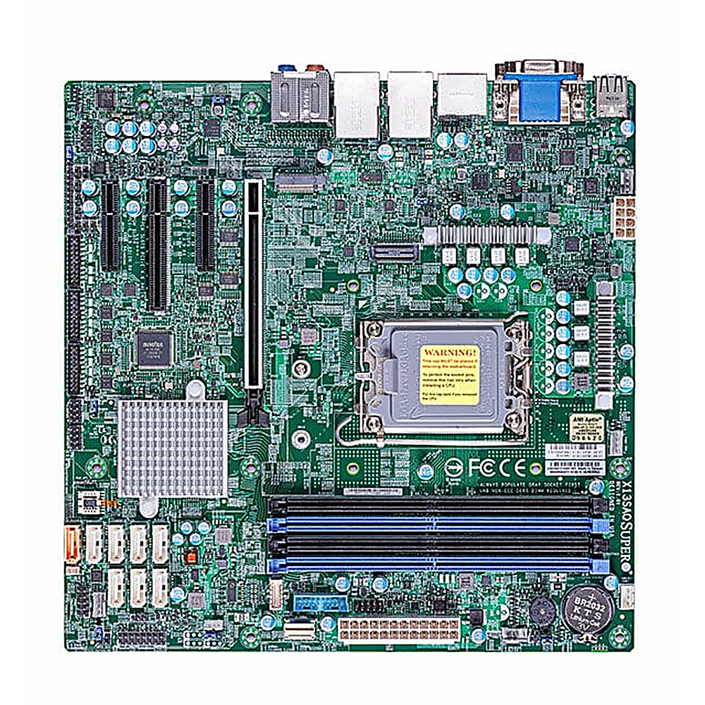 Una scheda madre verde per computer con vari componenti come porte, chip e slot. Contiene un'etichetta di avvertimento e una batteria.