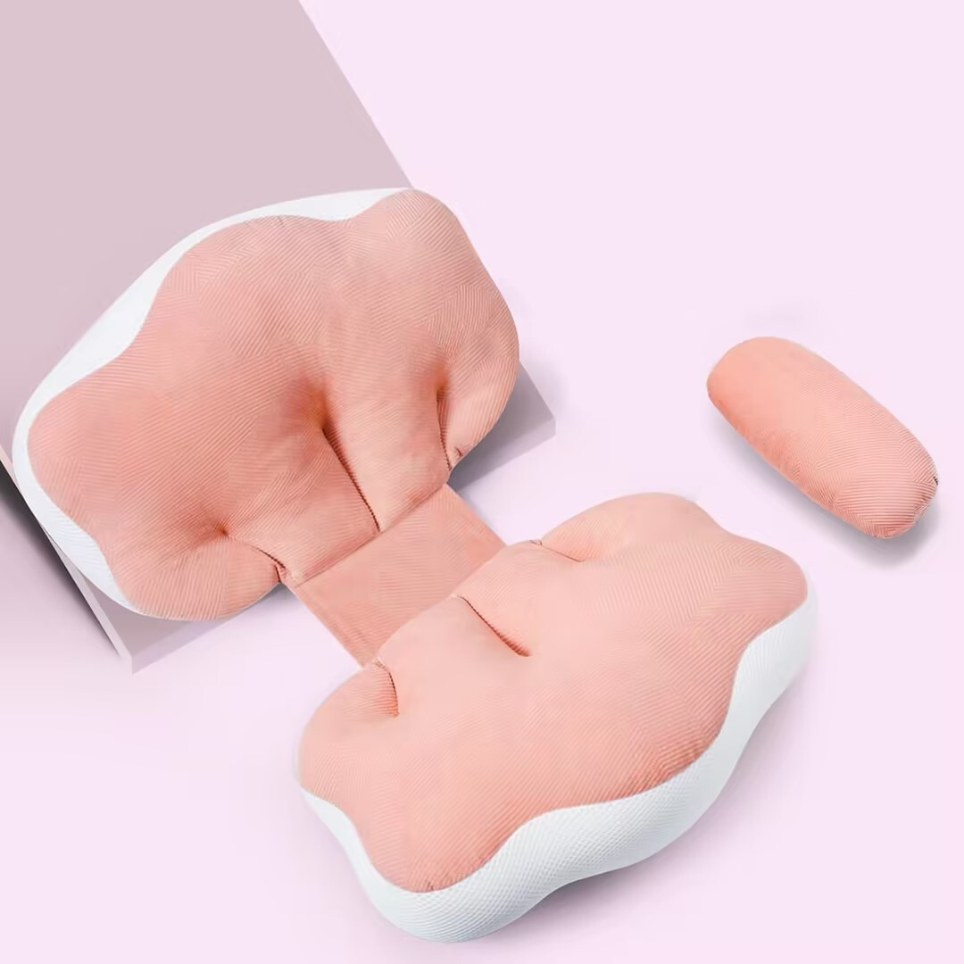 Ein rosa Kissenset mit zwei Hauptteilen und einer kleinen, separaten Rolle. Der Hintergrund ist hellrosa.