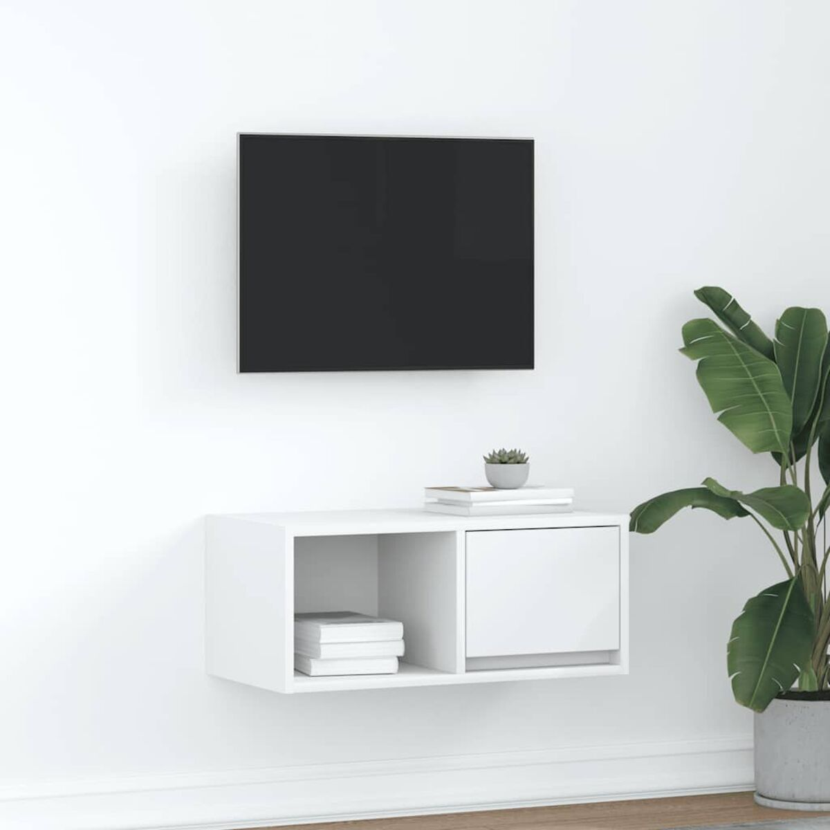 Ein an der Wand montierter Fernseher, ein schwebendes weißes Regal mit Büchern und einer kleinen Pflanze sowie eine große Topfpflanze.