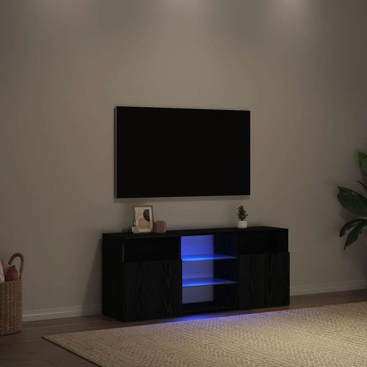 Wohnzimmer mit schwarzem TV-Schrank, Fernseher und Teppich. Eine Pflanze und ein Bilderrahmen stehen auf dem Schrank. Der Schrank hat blaue Lichter.