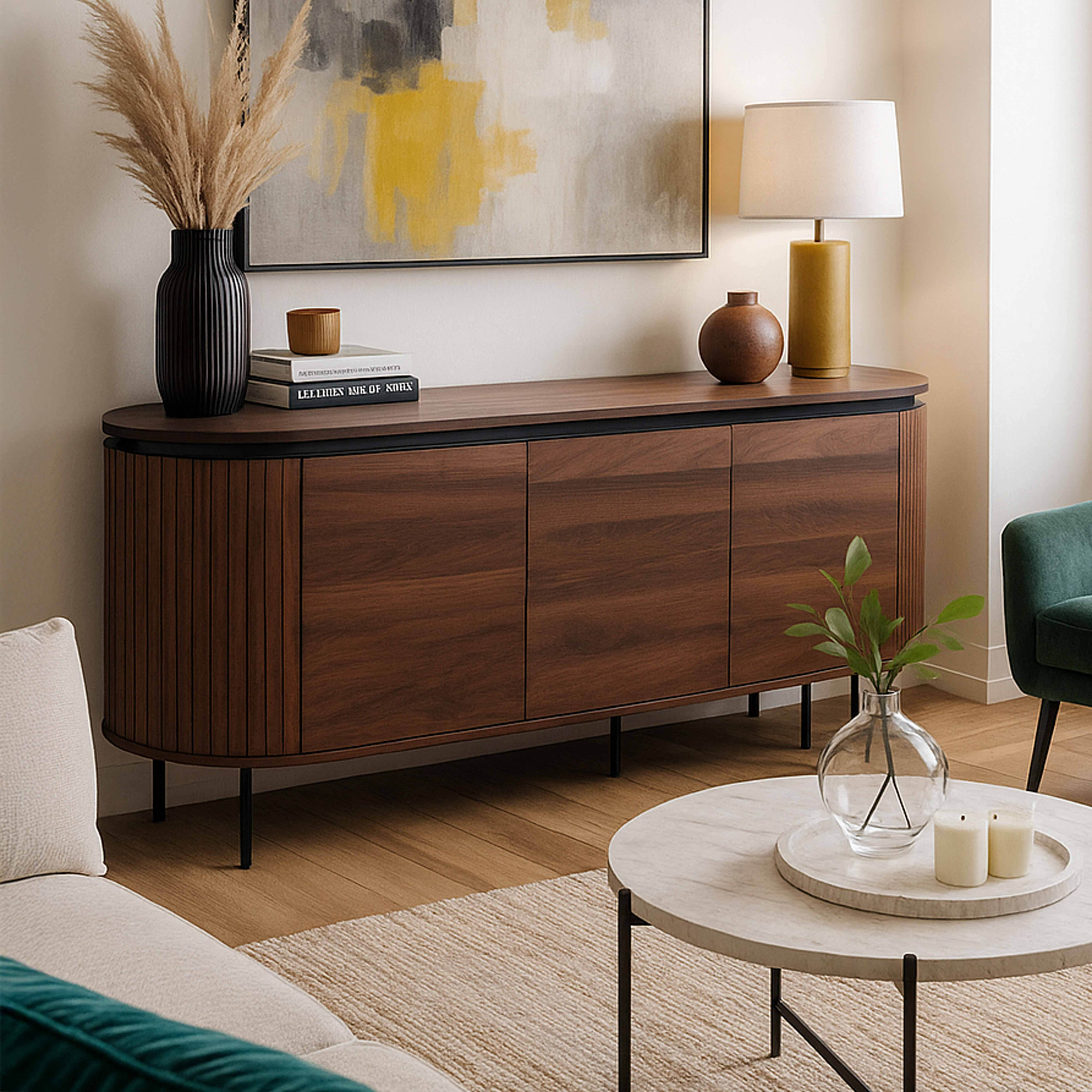 Ein Wohnzimmer mit einem Holzschrank, einem runden Couchtisch, einem Sofa und einem Gemälde. Trockenpflanzen in einer Vase.