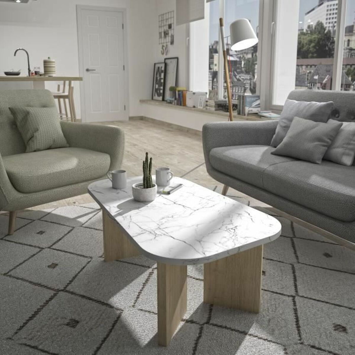 Wohnzimmer mit grauem Sofa, grünem Sessel, Marmortisch und gemustertem Teppich. Ein Kaktus steht auf dem Tisch. Fenster mit Stadt.