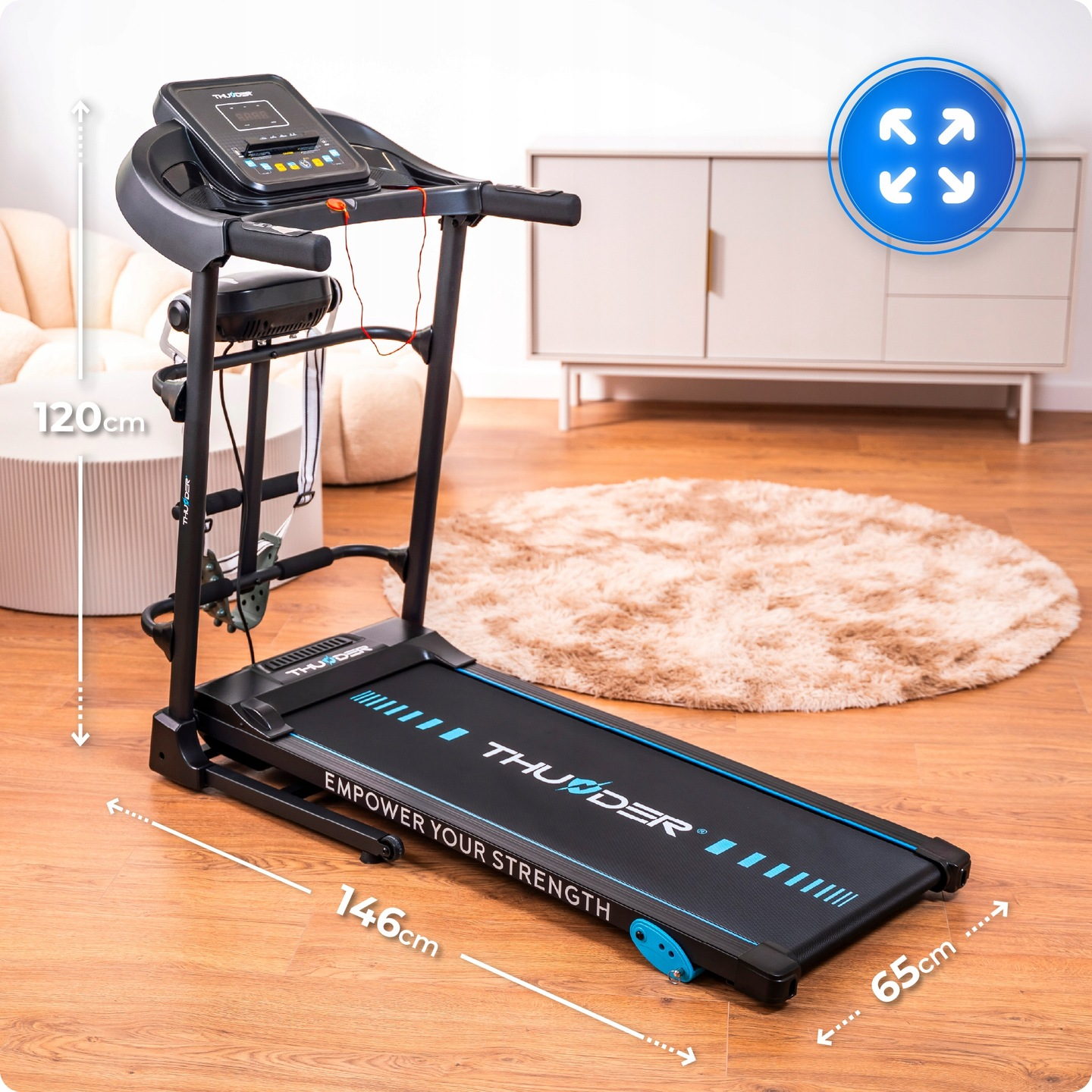 Czarna bieżnia z niebieskimi akcentami. Stoi na drewnianej podłodze, z beżowym dywanem, białą szafką i beżowym krzesłem w tle.