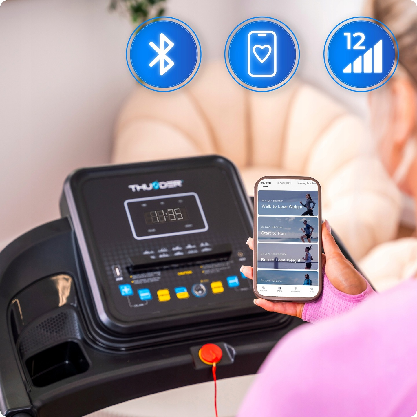 Osoba korzystająca z bieżni. Telefon wyświetla opcje treningu. Widoczne ikony Bluetooth, serca i sygnału. Czas to 00:35.