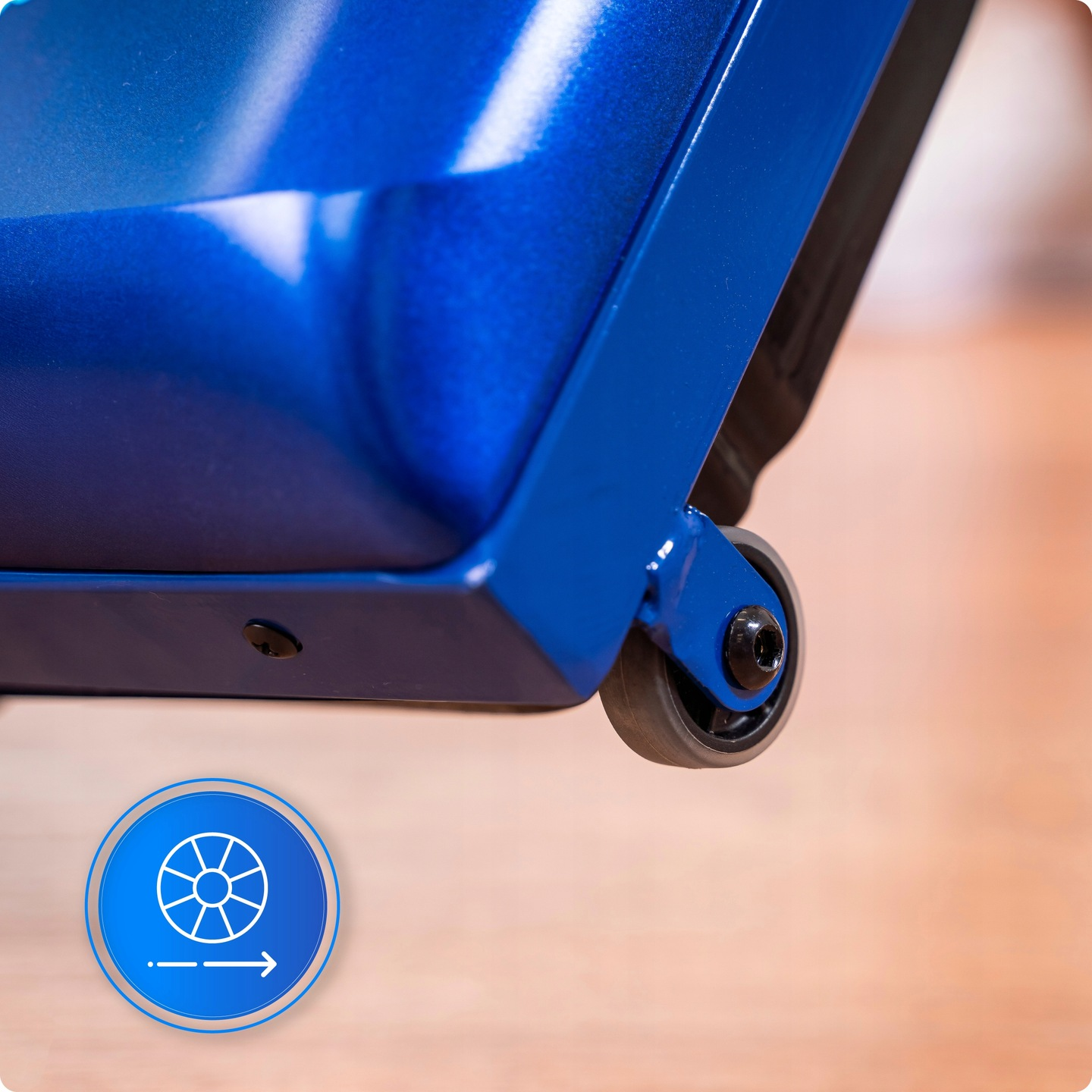 Niebieski metalowy przedmiot z małym kółkiem na drewnianej powierzchni. Niebieska ikona okręgu ze strzałką po lewej stronie.