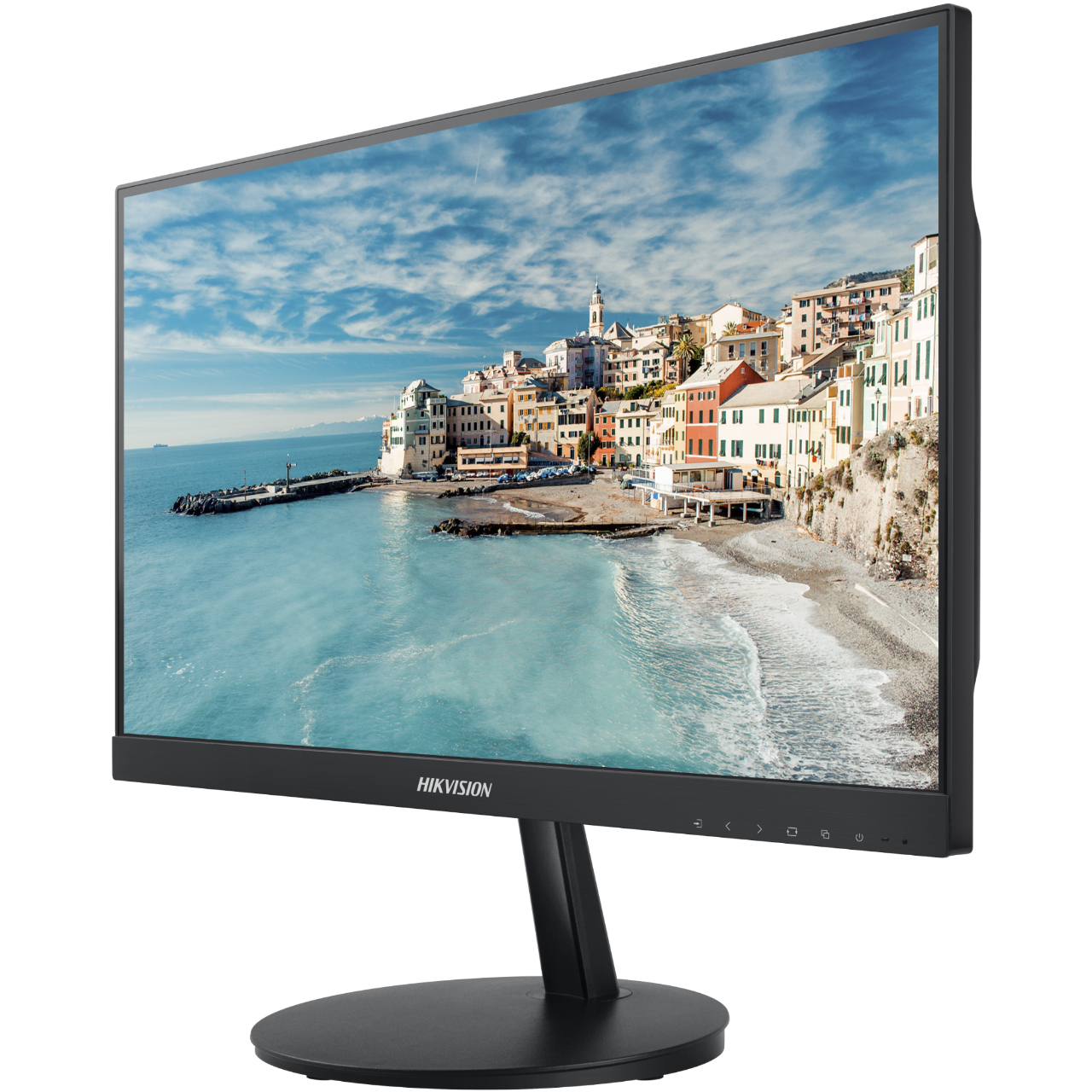 Un monitor muestra un pueblo costero con edificios coloridos, una playa y un mar azul bajo un cielo nublado. El monitor tiene un marco negro.