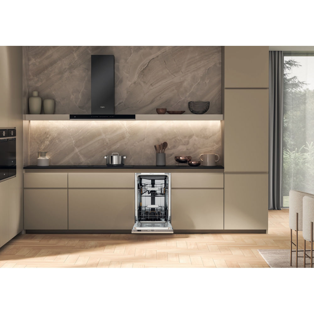 Una cocina moderna con lavavajillas abierto. Se ven armarios beige, una campana extractora negra y un salpicadero similar al mármol.