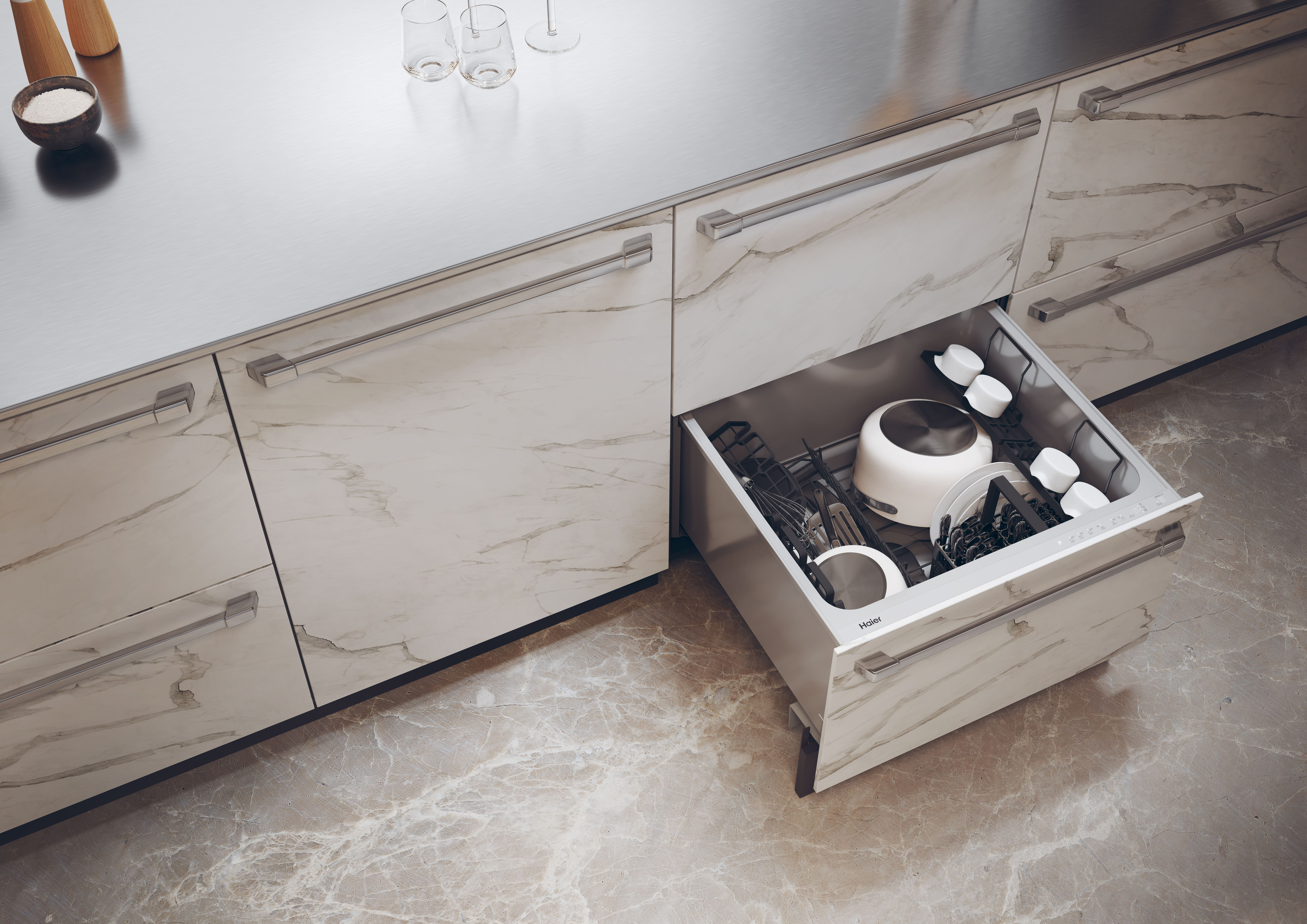 Cucina moderna con cassetto aperto. Contiene pentole e utensili. Piano e pavimento in marmo. Sale, pepe e bicchieri visibili.