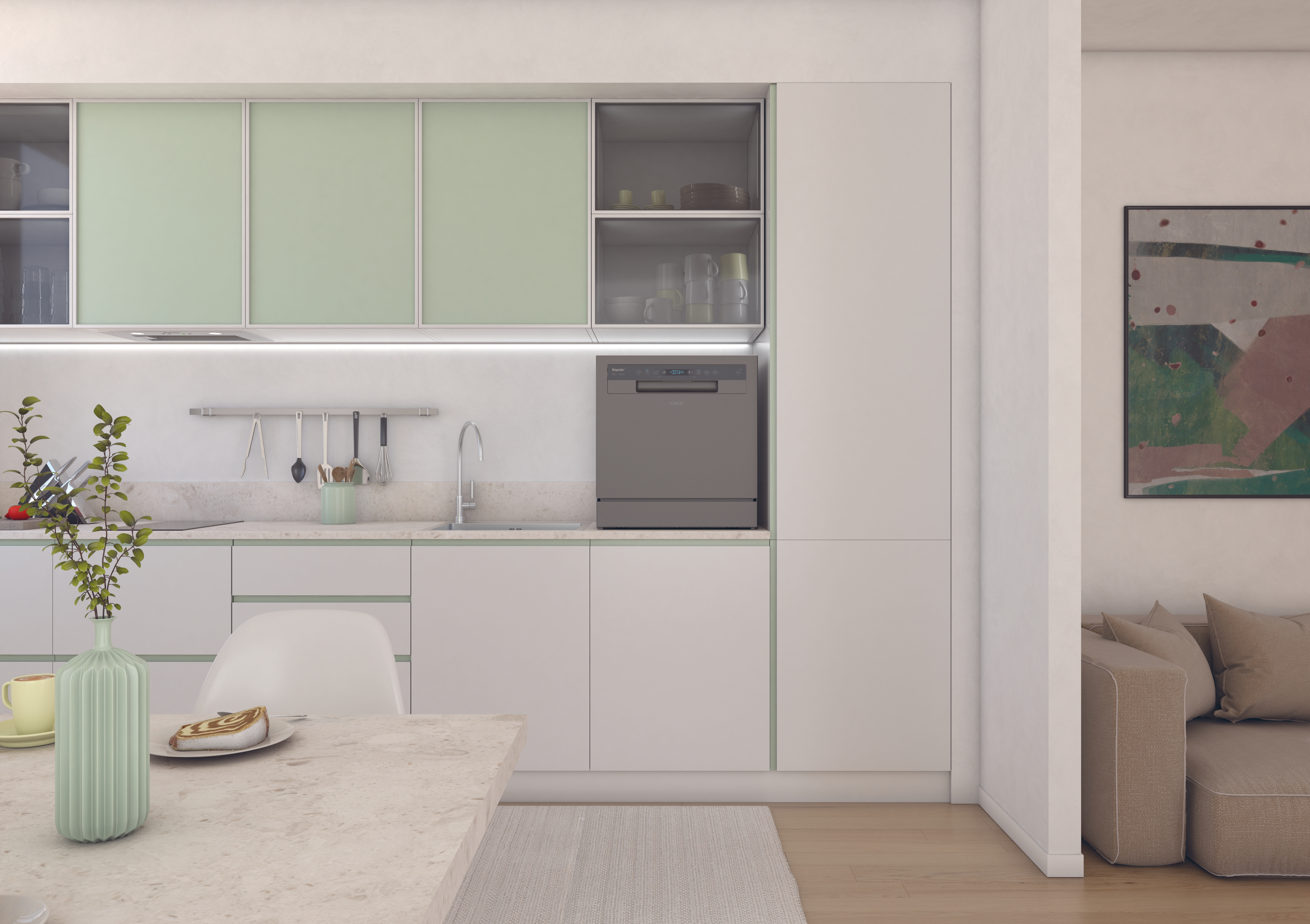 Cocina moderna con armarios blancos, detalles verde menta y lavavajillas. Mesa con pastel y jarrón. Sofá a la derecha.
