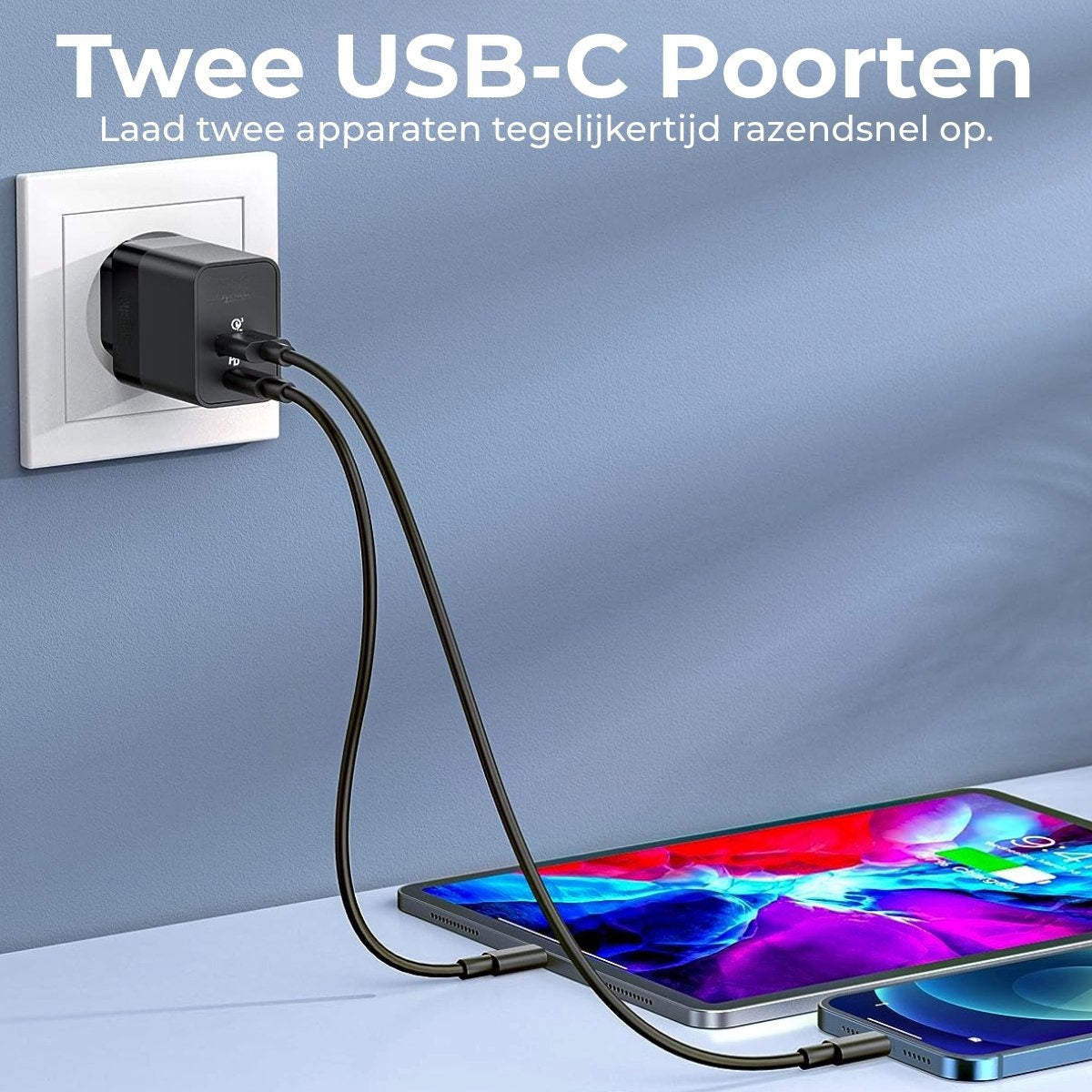 A black USB-C charger plugged into a wall outlet, charging a tablet and a phone. The devices are on a light-colored surface.