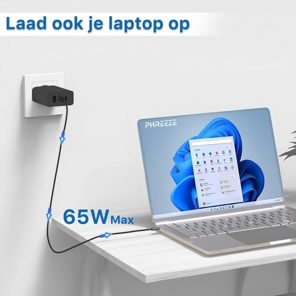 Laptop charging with a 65W adapter. The laptop is on a white table, plugged into an outlet. Screen shows a Windows interface.