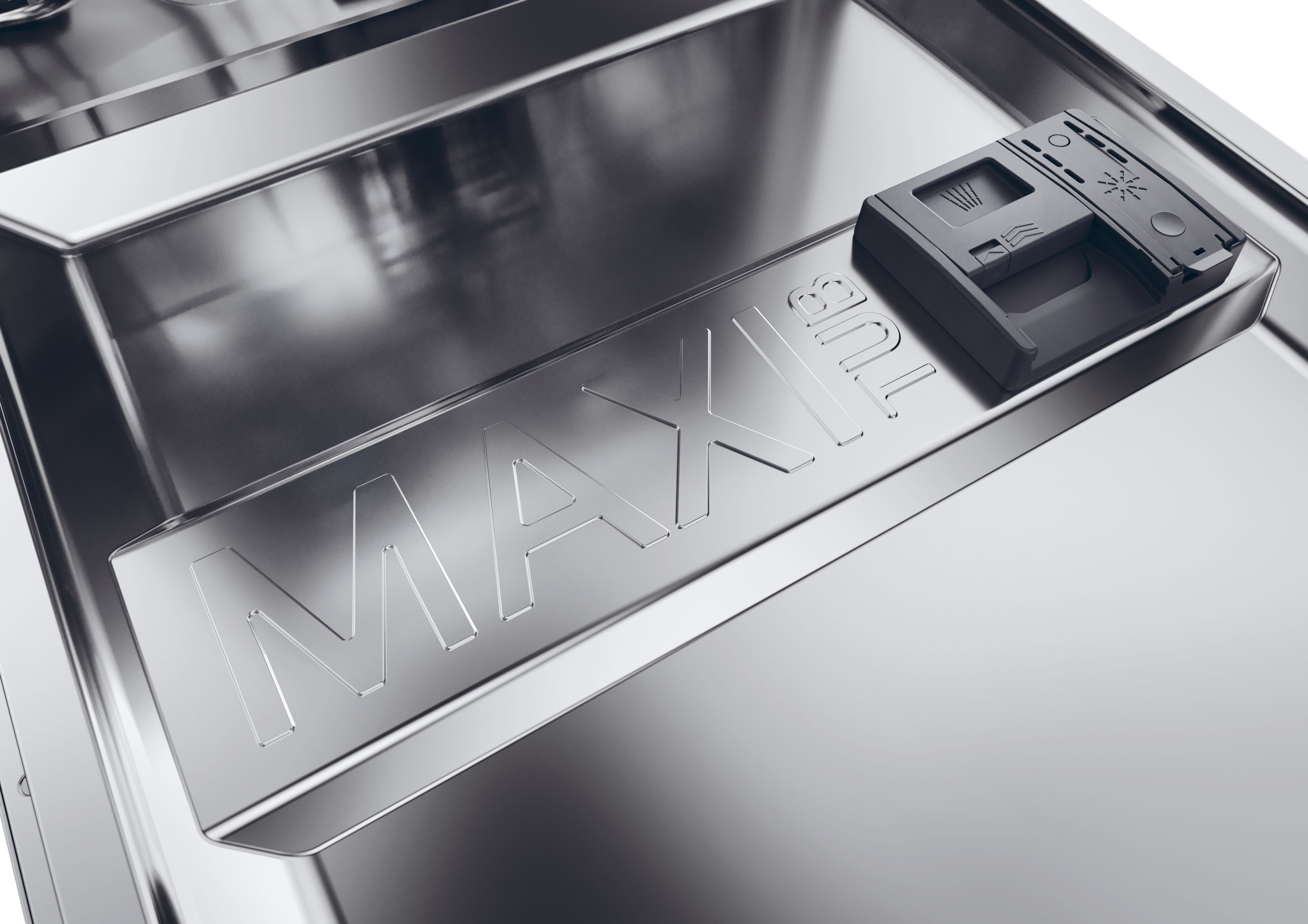 Primo piano dell'interno di una lavastoviglie. A destra c'è un dispenser grigio per detersivo. La parola MAX è in rilievo.