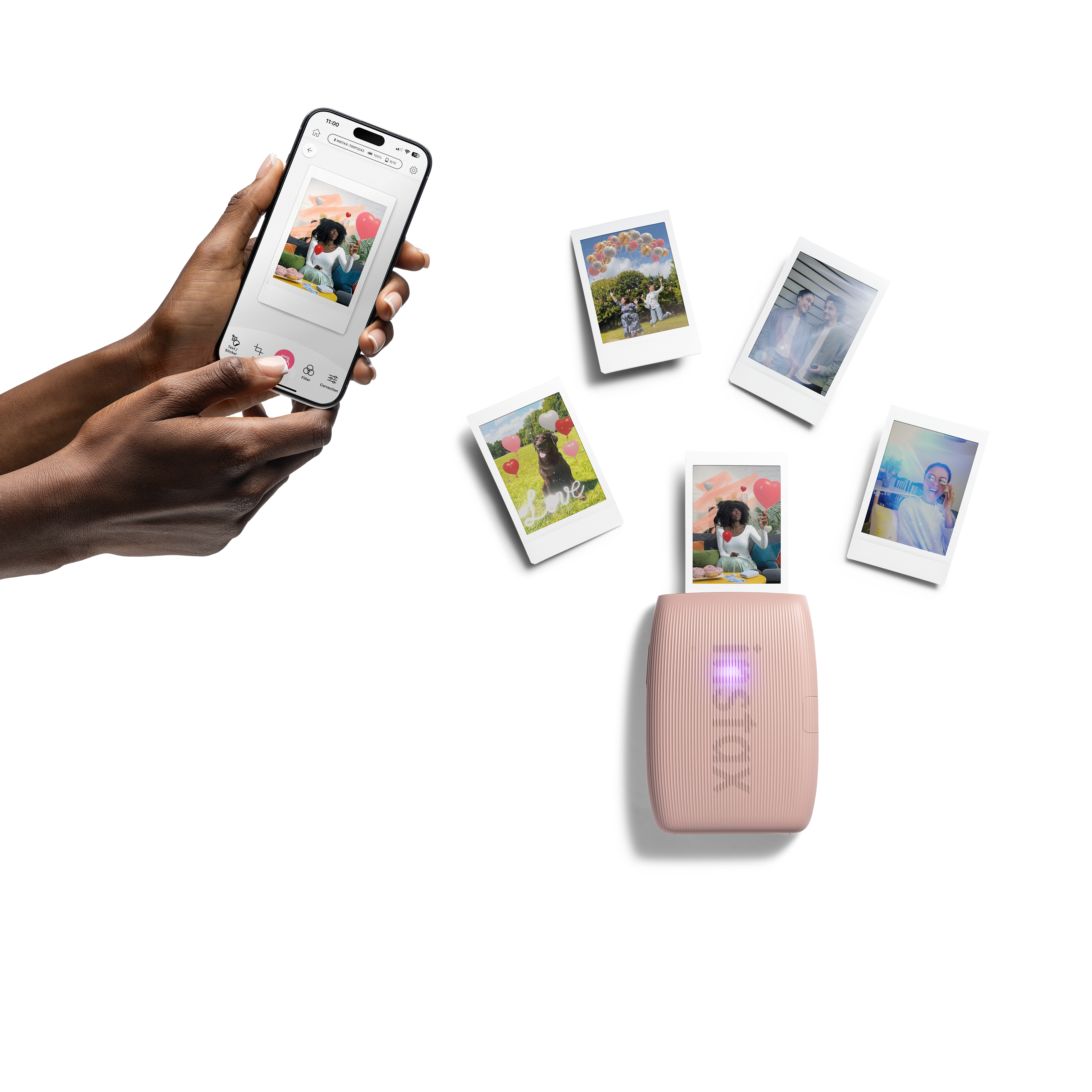 Mani che tengono il telefono con foto e diverse foto stampate. Stampante rosa in basso. Sfondo bianco.