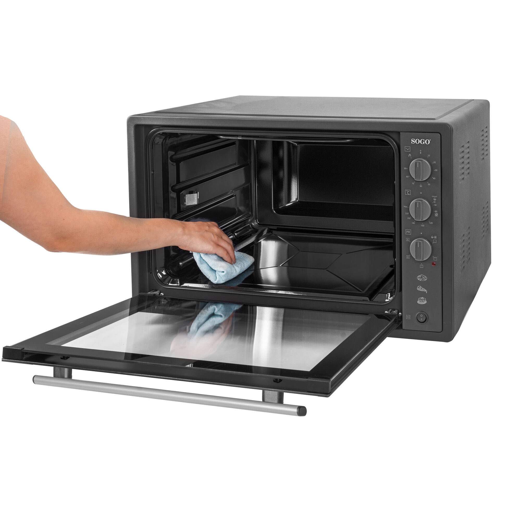 Una persona limpia un horno con un paño azul. La puerta del horno está abierta.