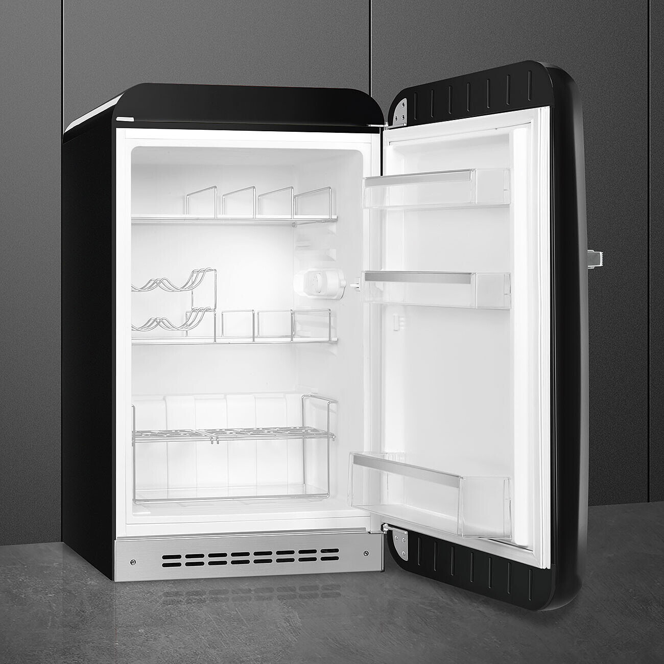 Un refrigerador negro abierto. El interior es blanco con estantes, botelleros y recipientes de plástico transparente. La puerta está abierta.