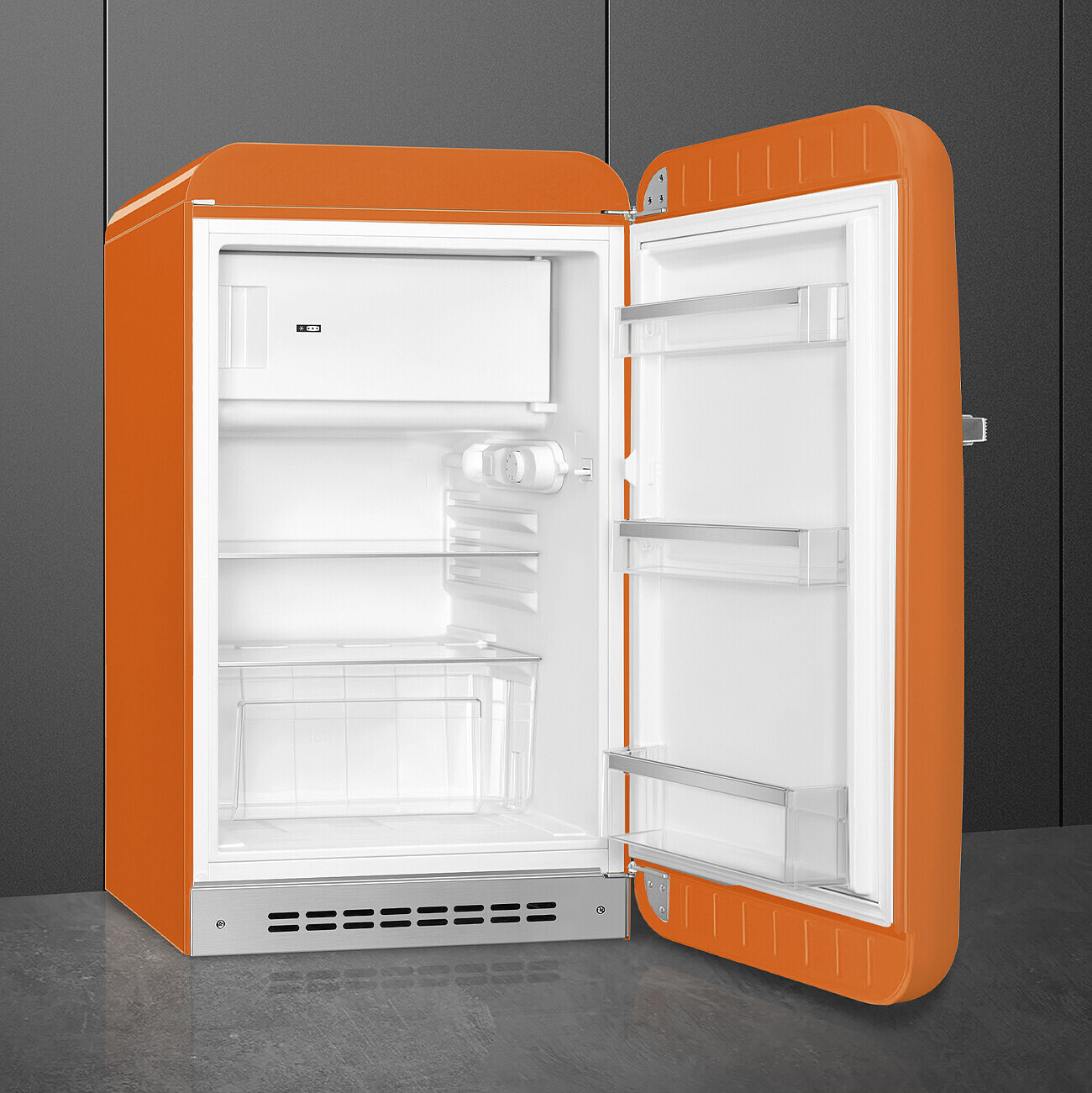 Un frigorifero retrò arancione è aperto. L'interno è bianco con ripiani, congelatore e un contenitore trasparente per prodotti. La porta è aperta.