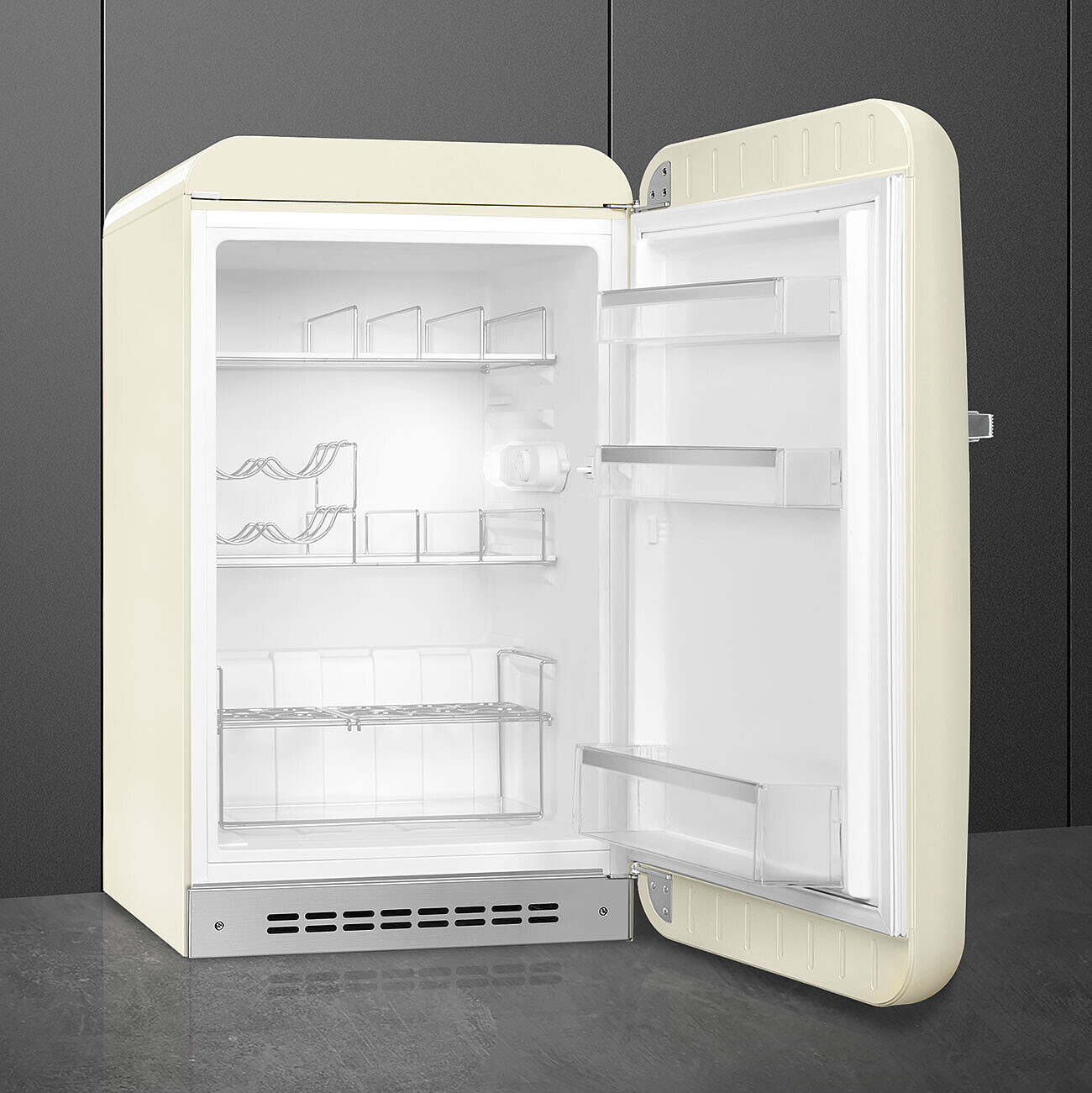 Refrigerador retro color crema con puerta abierta. Interior vacío con estantes. Fondo gris.