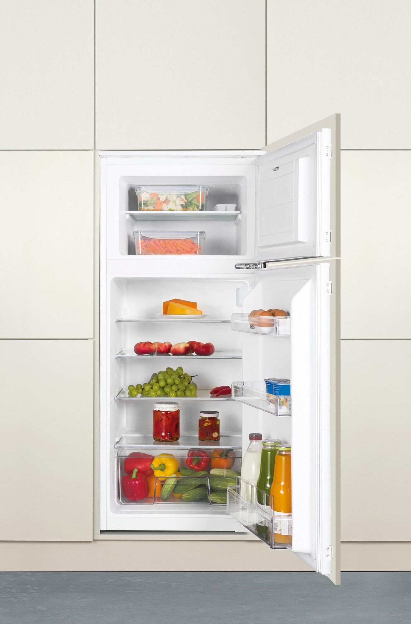 Offener Kühlschrank mit Obst, Gemüse, Käse, Eiern, Gläsern und Flaschen gefüllt. Weißer Innenraum mit hellfarbiger Wand dahinter.