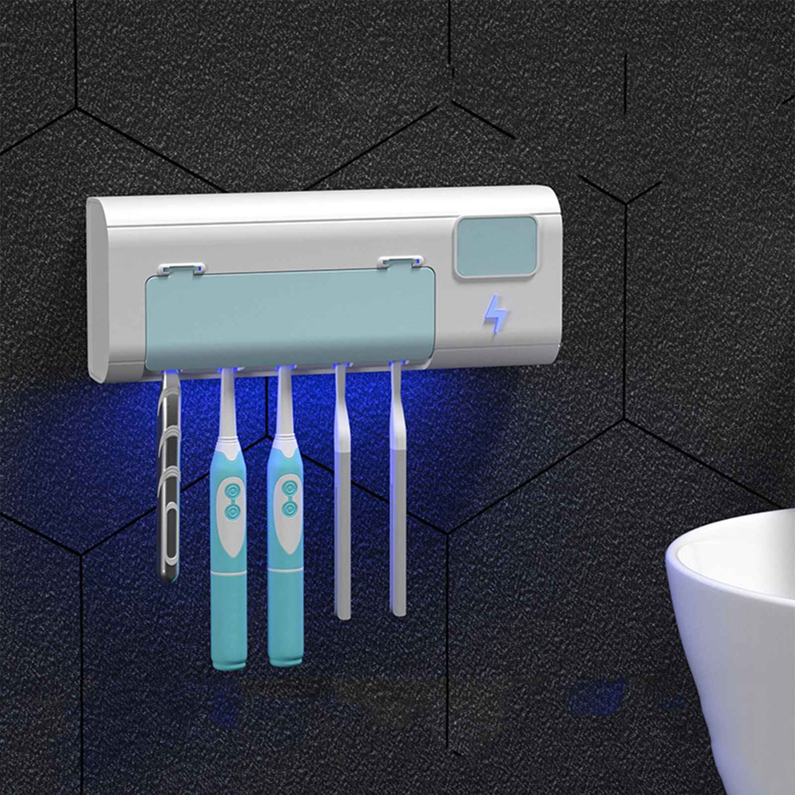 Ein an der Wand befestigter Zahnbürstenhalter mit vier Zahnbürsten, blauem Licht und einem weißen Waschbecken vor einer strukturierten schwarzen Wand.