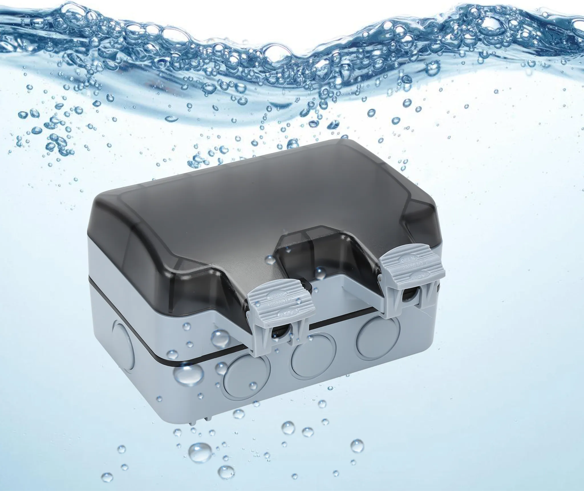 Eine graue elektrische Anschlussdose mit dunklem Deckel ist in Wasser getaucht. Blasen schweben um die Box.