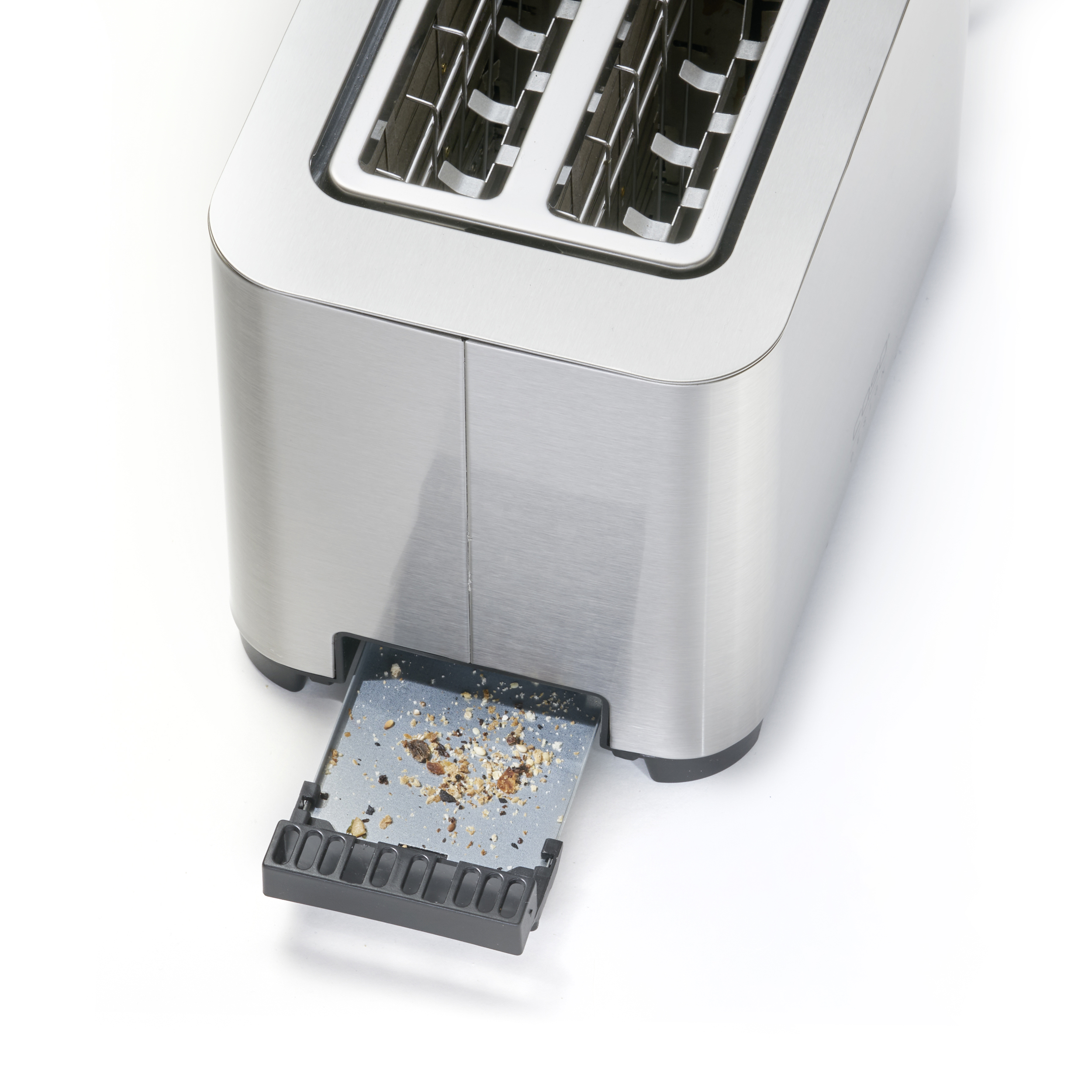 Ein Toaster aus Edelstahl mit herausgezogener Krümelschublade, gefüllt mit Krümeln, auf weißem Hintergrund.