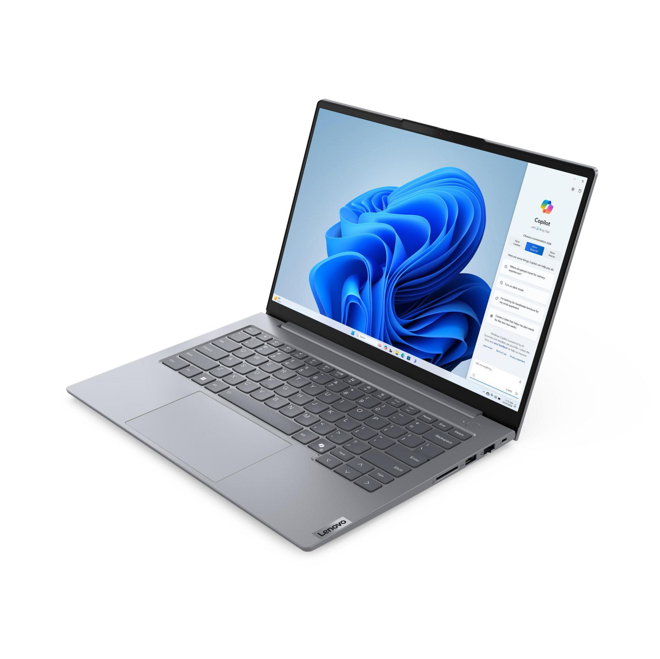 Laptop Lenovo argentato su bianco. Lo schermo mostra Windows Copilot. La tastiera è visibile. Lo sfondo è bianco.