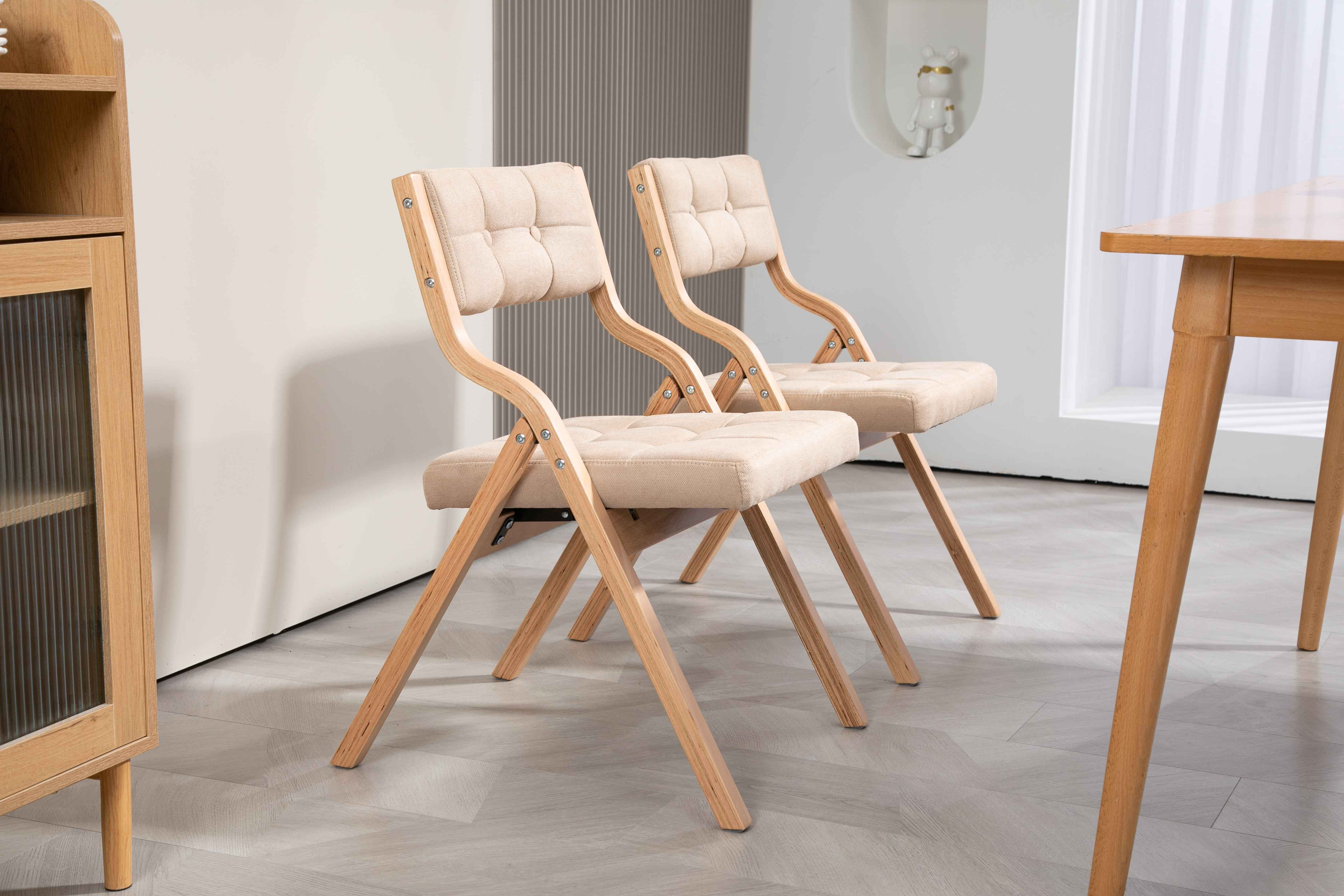 Zwei beige gepolsterte Stühle mit Holzrahmen. Links ein Holzschrank. Rechts ein Tisch.