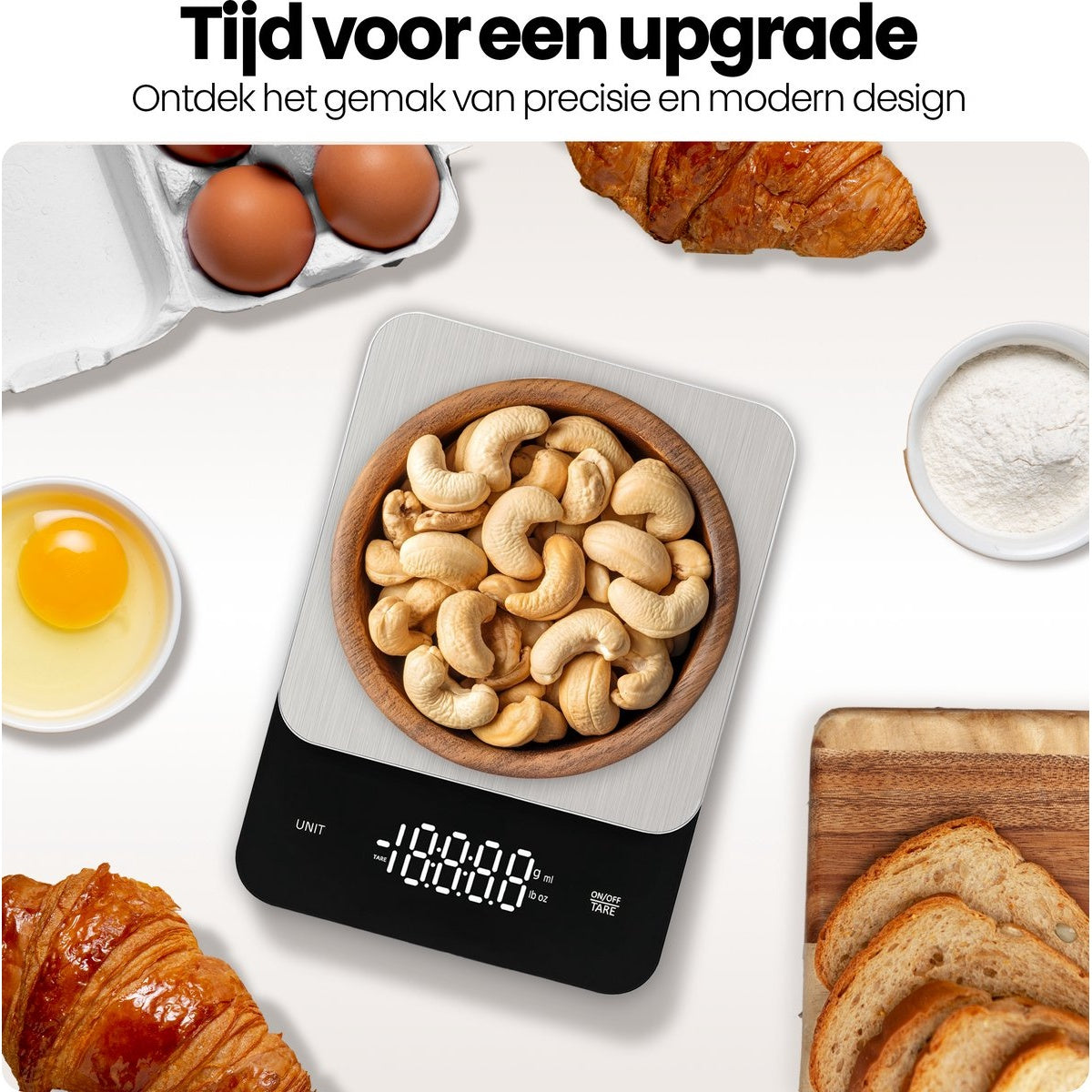 A digital kitchen scale with cashews, eggs, croissant, bread, and flour. The scale displays numbers. White surface background.