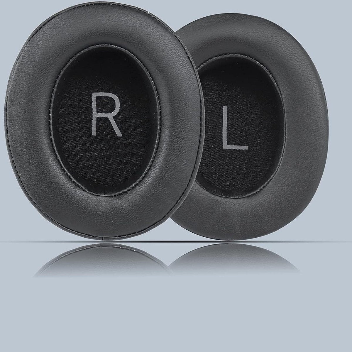 Twee zwarte oorkussens voor een koptelefoon, een met 'R' en de andere met 'L'. Ze worden weerspiegeld op een lichtgrijze ondergrond.
