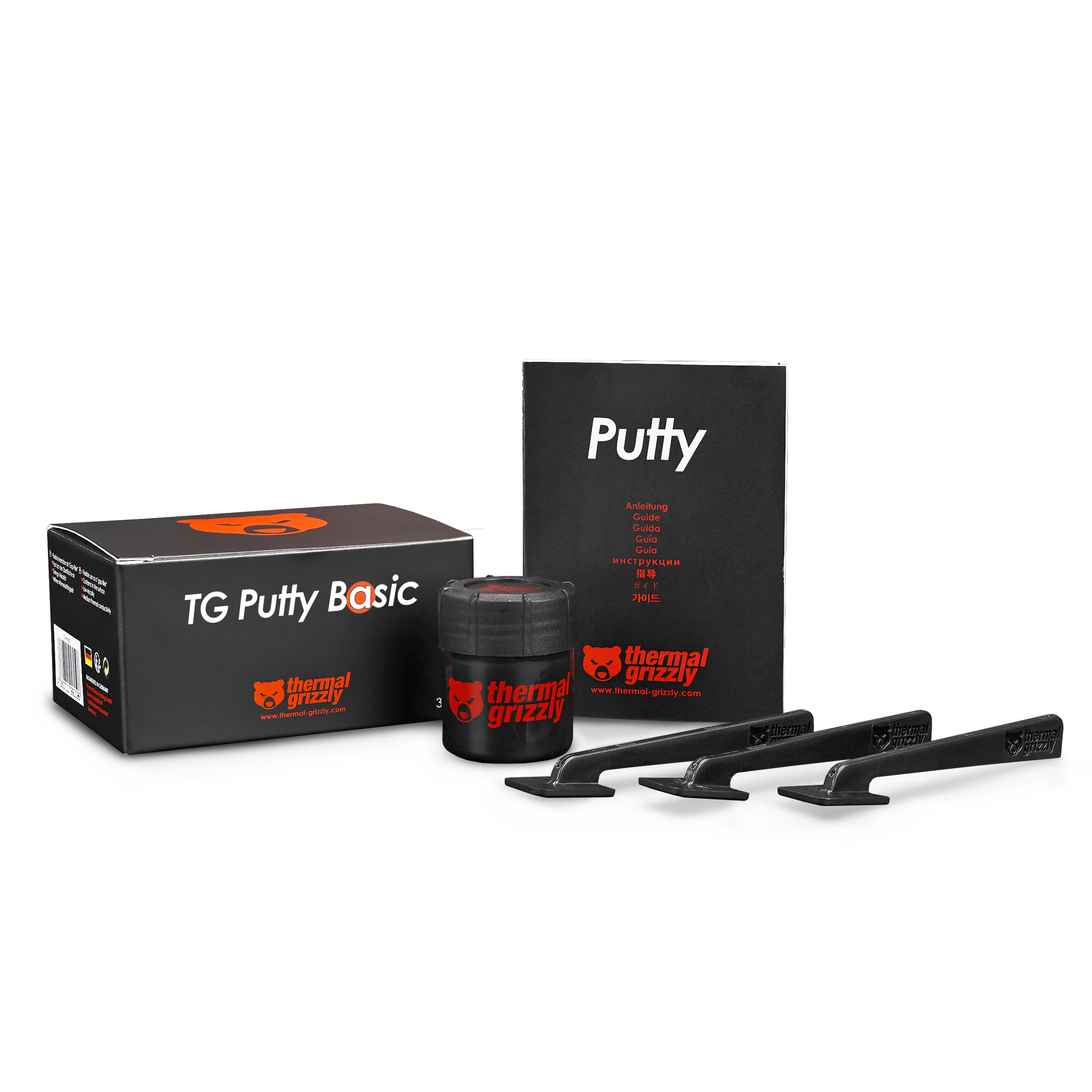 Produktaufnahme von Thermal Grizzly TG Putty Basic, schwarzen Behältern, Kitt und Applikatoren auf weißem Hintergrund.