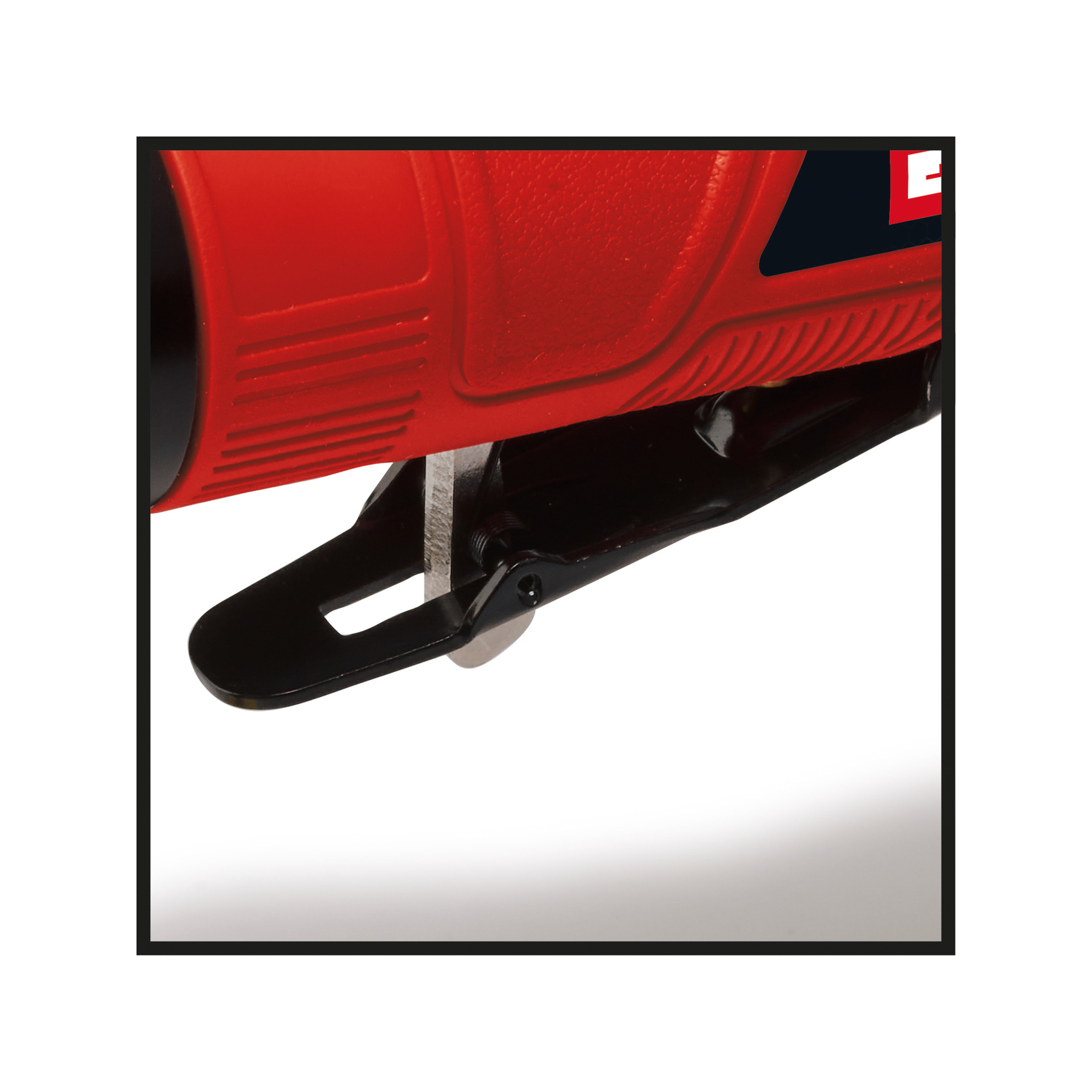 Zbliżenie czerwonej wyrzynarki. Czarne detale i metalowe ostrze widoczne na białym tle.