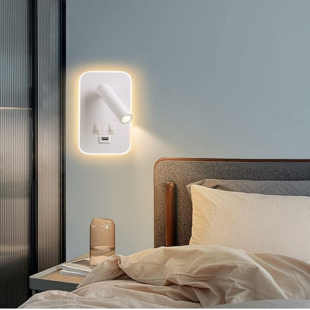 Eine weiße Wandlampe mit schwenkbarem Kopf ist an einer hellblauen Wand angebracht. Darunter ein Bett mit beigem Bettzeug und Kissen.