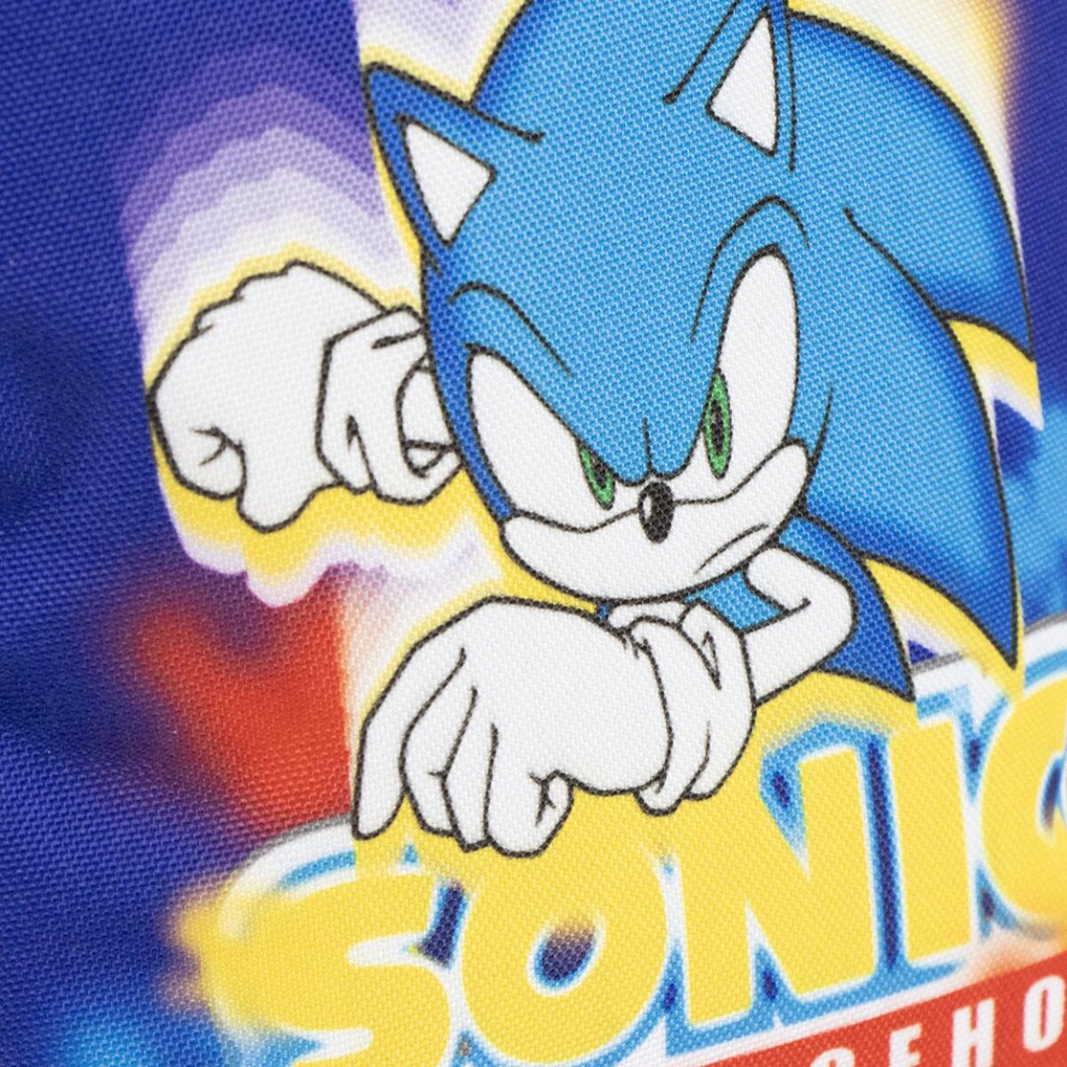 Primer plano de Sonic the Hedgehog. Se ve pelaje azul, guantes blancos, ojos verdes y la palabra 'SONIC' en amarillo.