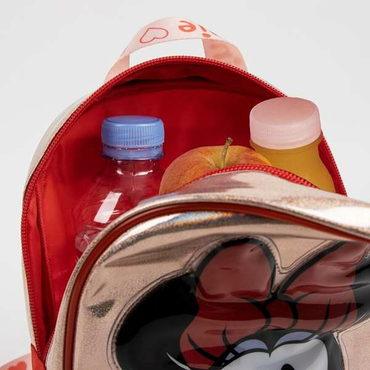 Offener Minnie-Mouse-Rucksack mit Wasserflasche, Apfel und Saft. Die Tasche ist rosa und gold mit roter Innenseite.