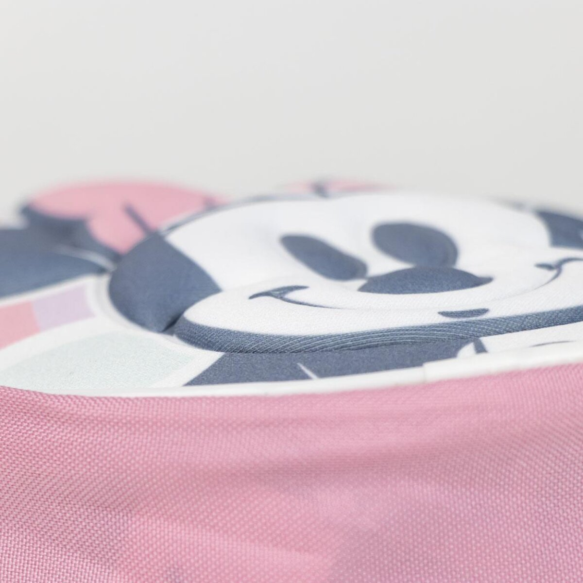 Primer plano de un artículo rosa con una cara de Minnie Mouse en la parte superior. El fondo es blanco.