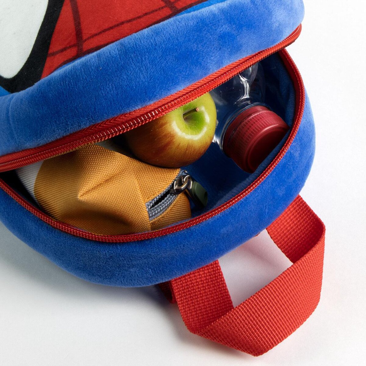 Ein blauer Spider-Man-Rucksack, der geöffnet ist und einen Apfel, eine Wasserflasche und einen gelben Beutel zeigt. Roter Griff und Reißverschluss.