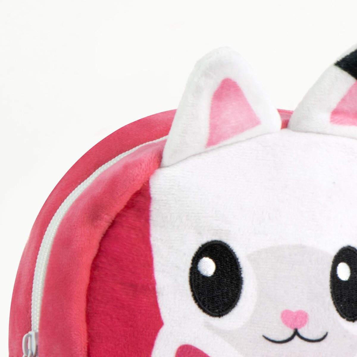 Ein Plüsch-Katzenrucksack. Er ist rosa und weiß mit Katzenmerkmalen: Ohren, Augen, Nase und einem Reißverschluss. Der Hintergrund ist weiß.