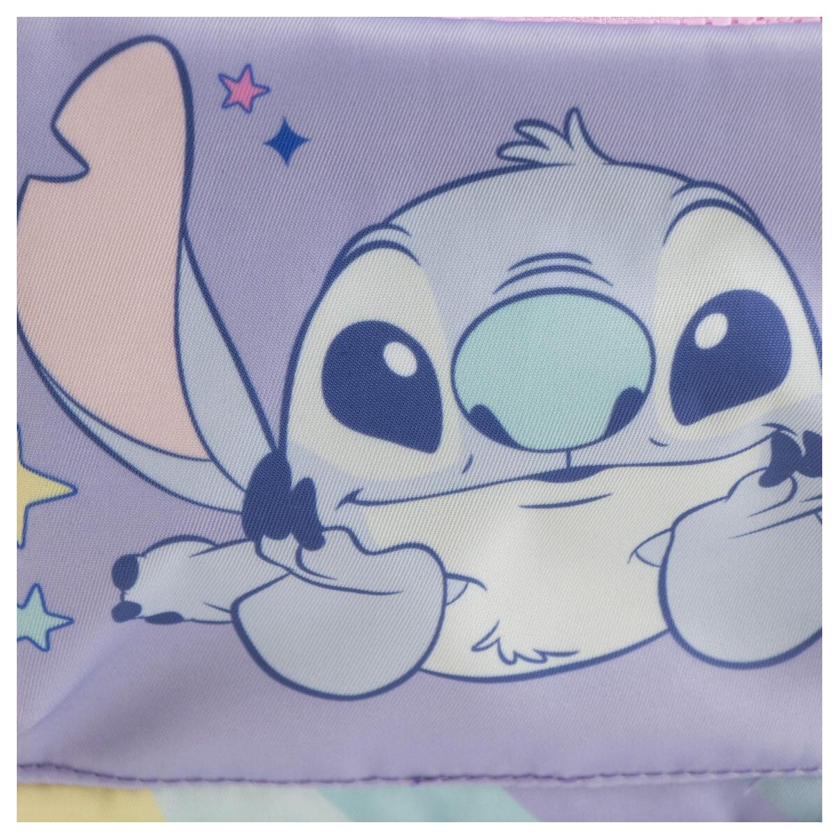 Personaje de dibujos animados Stitch sobre un fondo morado con estrellas. El personaje tiene ojos grandes, orejas y nariz azul, sonriendo.