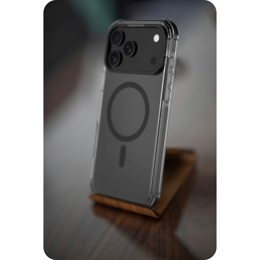 Eine transparente Handyhülle mit schwarzem Kameramodul steht auf einem Holzständer. Das Handy hat ein MagSafe-Kreisdesign und ist angewinkelt.