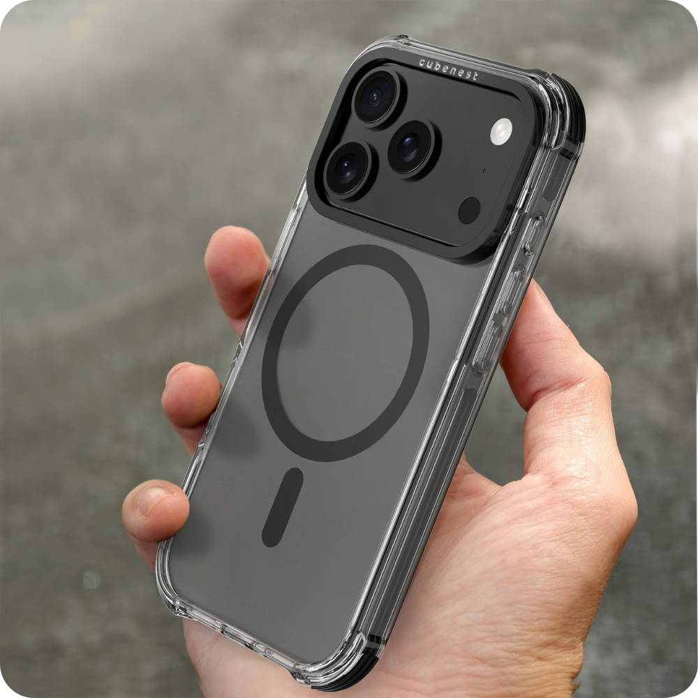 Hand hält eine transparente Handyhülle über einem Telefon. Hülle hat einen schwarzen Kamerabereich und einen Magnetkreis. Grauer Hintergrund.