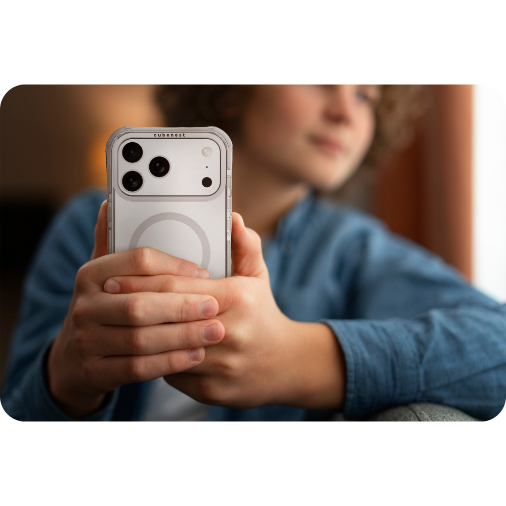 Eine Person hält ein Telefon in einer transparenten Hülle. Das Telefon hat drei Kameras. Die Person trägt ein blaues Hemd.